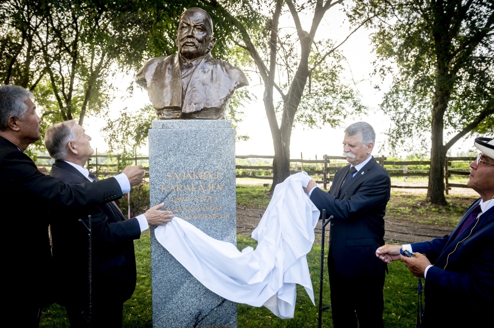 Felavatták a kirgiz Szajakbaj Karalajev szobrát a lakiteleki Hungarikum Ligetben Szöveg:	Lakitelek, 2023. augusztus 28. Kövér László, az Országgyűlés elnöke (j2), Szujunbek Kaszmambetov, a Kirgiz Köztársaság államtitkára (j), Lezsák Sándor, az Országgyűlés fideszes alelnöke, a lakiteleki Népfőiskola Alapítvány kuratóriumának elnöke (b2) és Szultan Raev, az ankarai központú Türk Nemzetközi Kulturális Szervezet, a Türksoy főtitkára leleplezi Szajakbaj Karalajev, a Manasz kirgiz őseposz énekmondójának szobrát Lakiteleken 2023. augusztus 28-án. Lantos Györgyi szobrászművész alkotása a Hungarikum Ligetben kapott helyet. MTI/Ujvári Sándor
